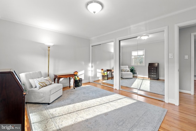 living room featuring baseboards, wood finished floors, and crown molding