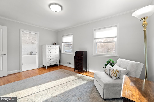 living area with baseboards, ornamental molding, and wood finished floors