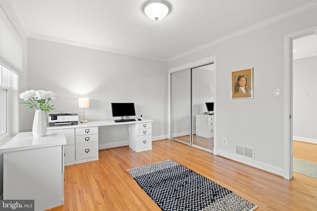 office space with light wood-style floors, visible vents, ornamental molding, and baseboards