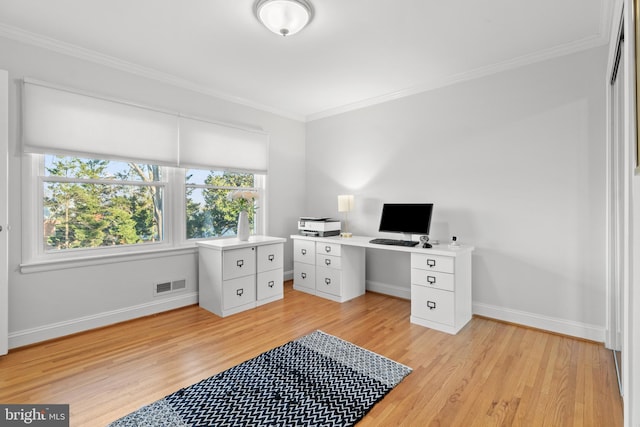 office space with light wood-style floors, baseboards, visible vents, and ornamental molding