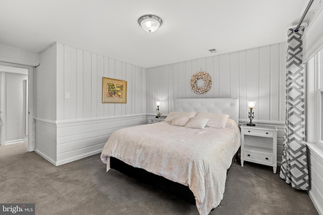 bedroom with visible vents and dark carpet