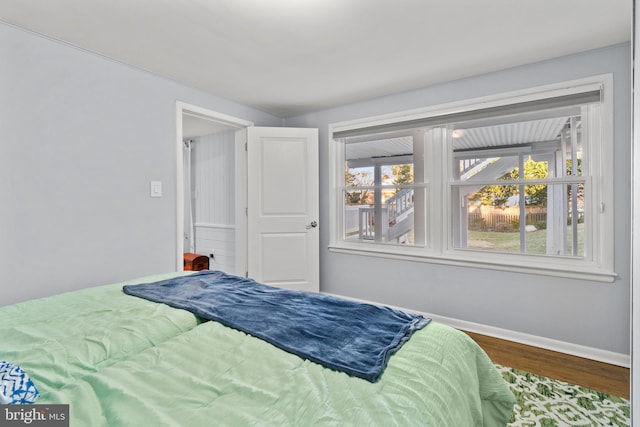 bedroom featuring baseboards and wood finished floors