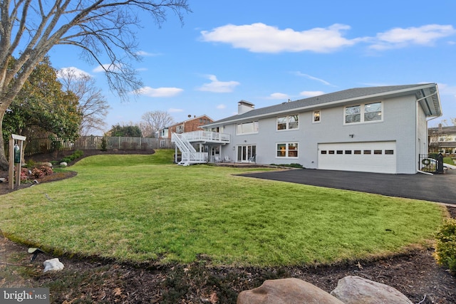 exterior space featuring aphalt driveway, fence, a deck, a garage, and stairs