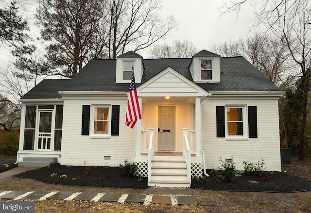 cape cod house featuring a sunroom