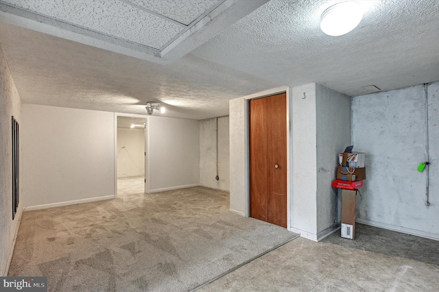 basement featuring a textured ceiling and carpet flooring