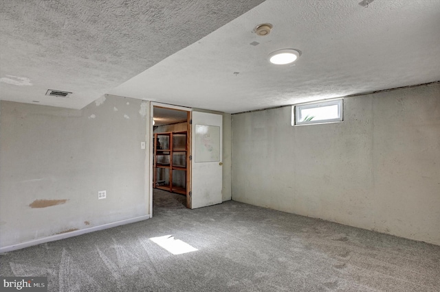 basement featuring carpet flooring and a textured ceiling