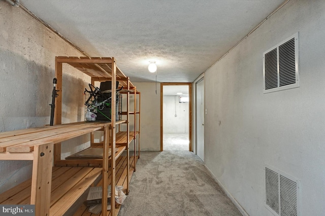 corridor with carpet and a textured ceiling