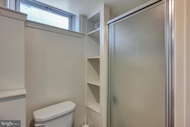 bathroom with toilet and a shower with shower door