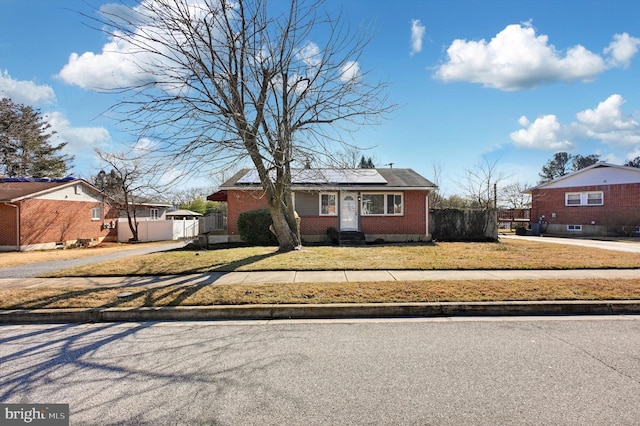 view of front facade with a front yard and solar panels