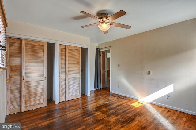 unfurnished bedroom featuring ceiling fan, dark hardwood / wood-style floors, and multiple closets