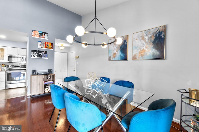 dining area featuring dark wood finished floors, a chandelier, and baseboards