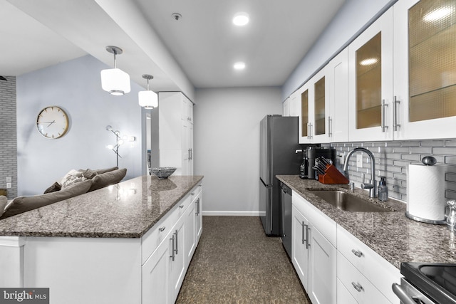 kitchen featuring dishwasher, dark stone counters, white cabinetry, and a sink