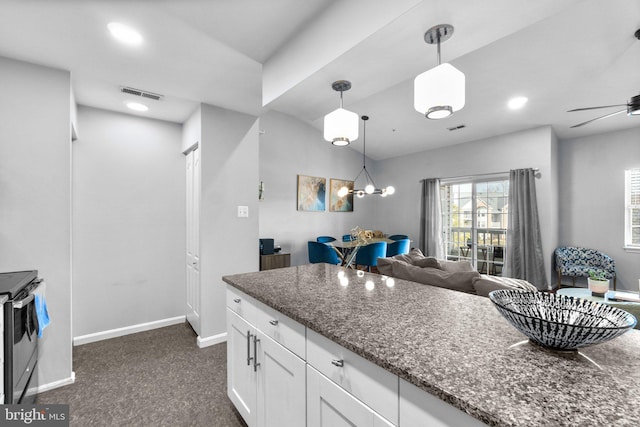 kitchen with visible vents, decorative light fixtures, open floor plan, white cabinetry, and baseboards