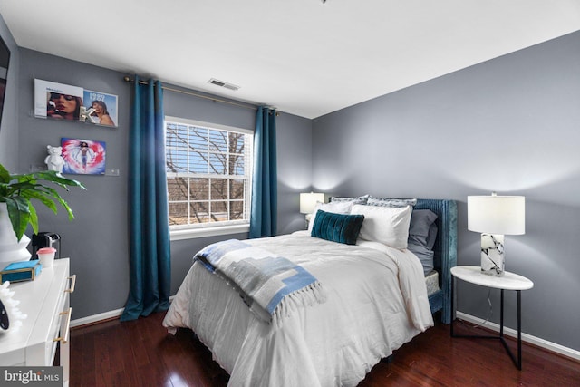 bedroom featuring visible vents, baseboards, and wood finished floors