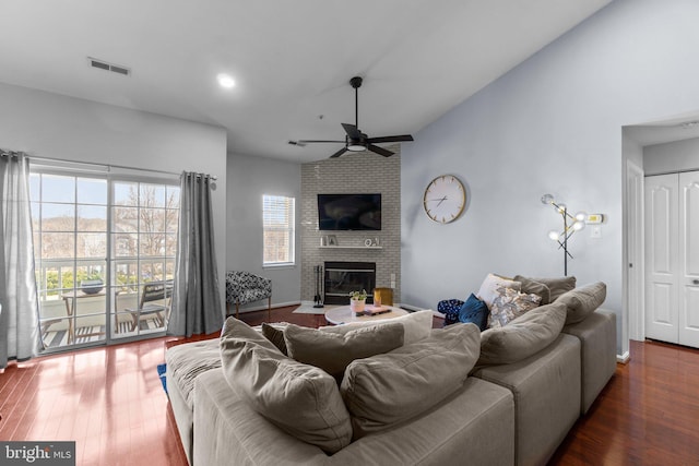 living room with visible vents, high vaulted ceiling, a ceiling fan, wood finished floors, and a fireplace