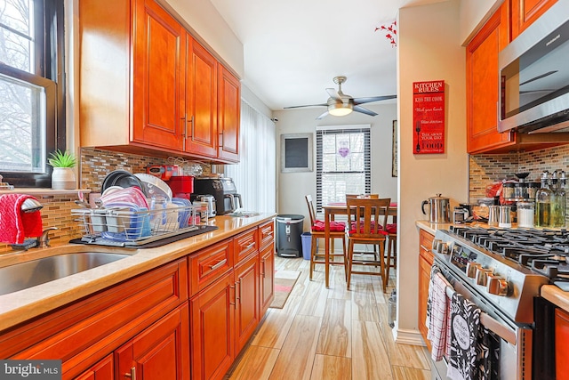 kitchen featuring tasteful backsplash, sink, stainless steel appliances, and ceiling fan