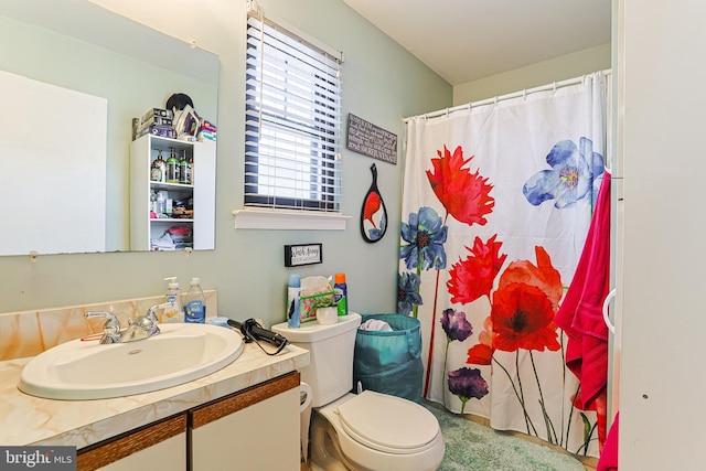 bathroom featuring vanity, walk in shower, and toilet