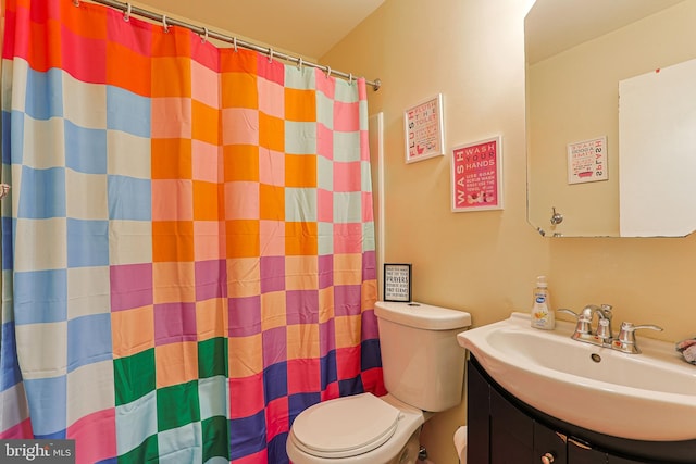 bathroom featuring vanity, walk in shower, and toilet