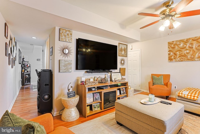 living room featuring wood-type flooring and ceiling fan