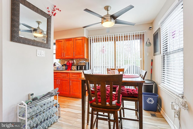 dining space with light hardwood / wood-style floors and ceiling fan