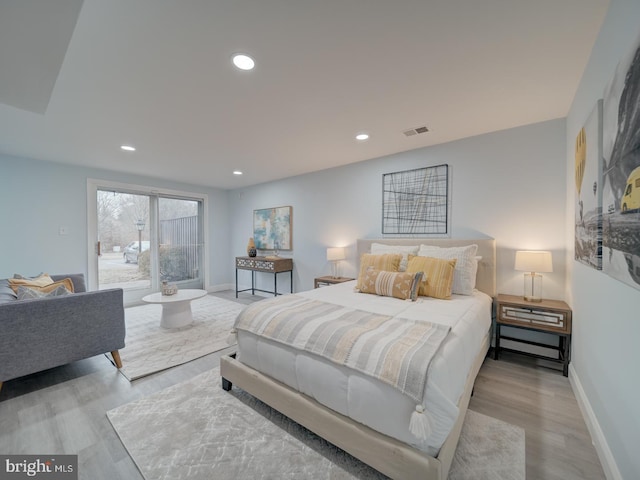 bedroom with access to exterior and light hardwood / wood-style floors