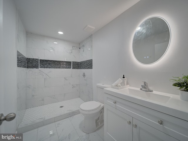 bathroom featuring vanity, toilet, and a tile shower