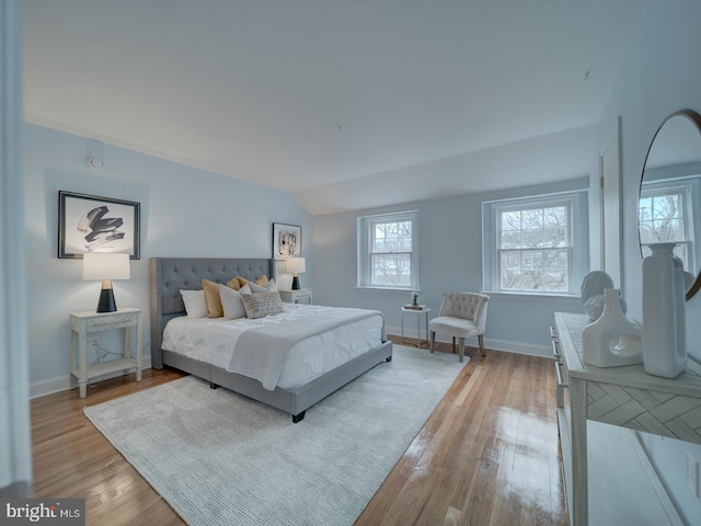 bedroom featuring vaulted ceiling and light hardwood / wood-style flooring