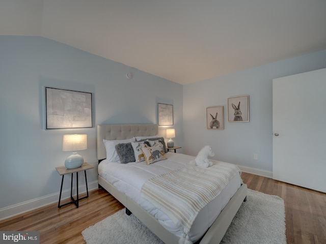 bedroom featuring lofted ceiling and light hardwood / wood-style floors