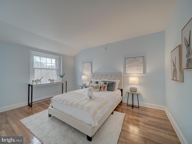 bedroom featuring lofted ceiling and light wood-type flooring