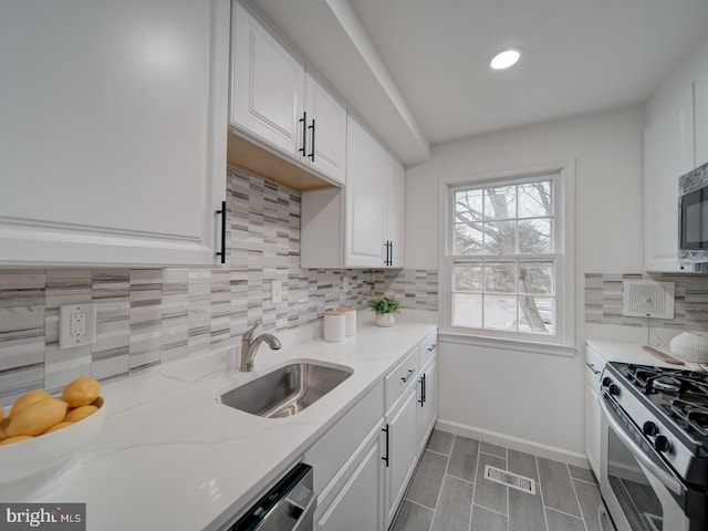 kitchen featuring stainless steel appliances, sink, and white cabinets