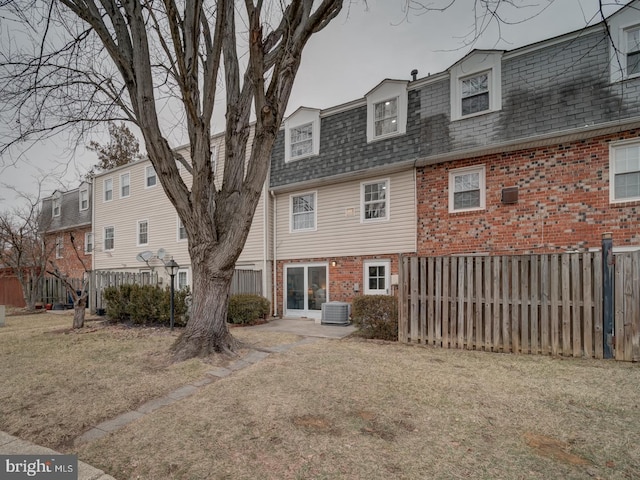 rear view of house with a yard and central air condition unit