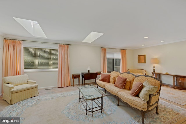 living room with ornamental molding and a skylight