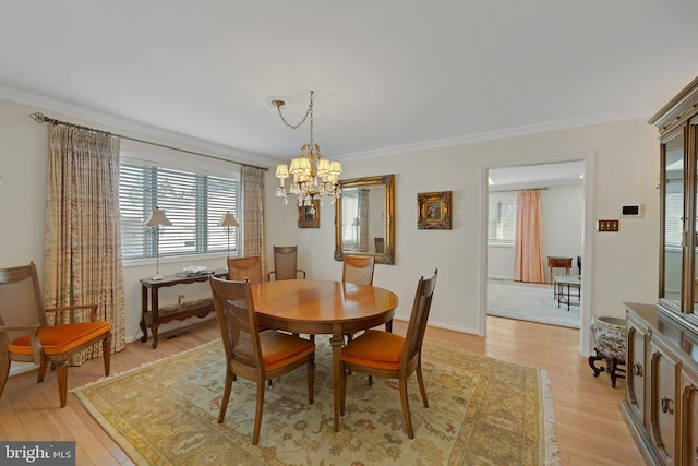 dining space featuring an inviting chandelier, crown molding, and light wood-type flooring