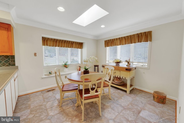 dining space featuring ornamental molding and a skylight