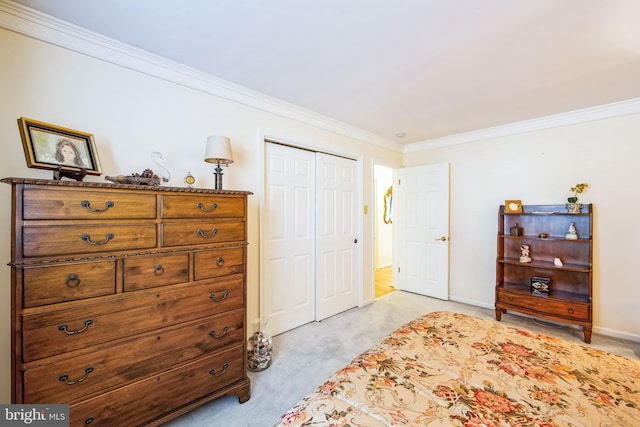 carpeted bedroom with ornamental molding and a closet