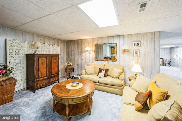 carpeted living room featuring a drop ceiling