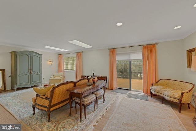 living area featuring crown molding, plenty of natural light, and light hardwood / wood-style floors