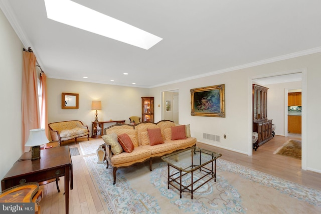 living room featuring crown molding, light hardwood / wood-style floors, and a skylight