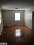 unfurnished room with dark hardwood / wood-style floors