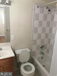 full bathroom with tiled shower / bath, vanity, and toilet