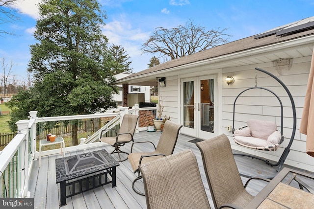 wooden terrace featuring a fireplace and french doors