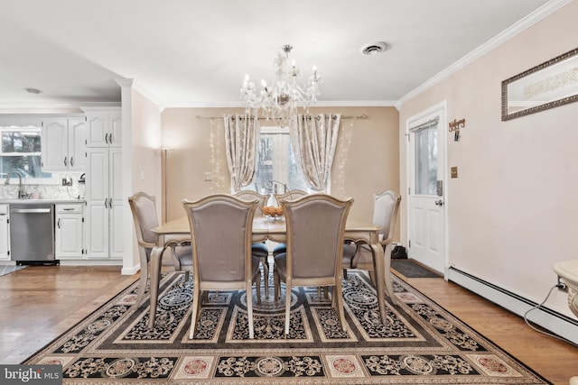 dining area featuring crown molding, plenty of natural light, a chandelier, and baseboard heating