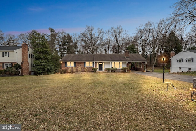 view of front facade with a lawn and a carport