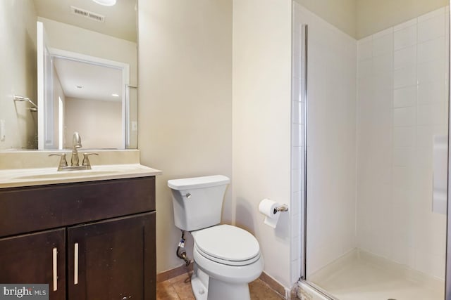 full bathroom with toilet, vanity, visible vents, baseboards, and a tile shower