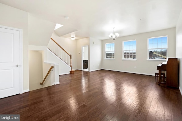 unfurnished living room featuring an inviting chandelier, stairway, baseboards, and dark wood finished floors