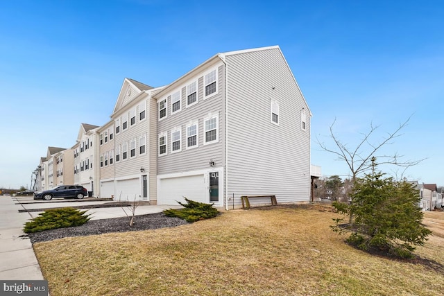 view of property exterior with a garage, concrete driveway, and a yard