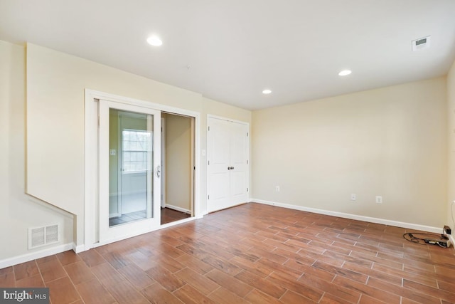 spare room featuring light wood-type flooring, visible vents, and recessed lighting