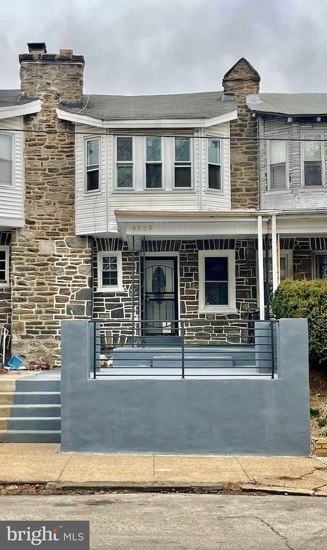 multi unit property featuring a porch and stone siding