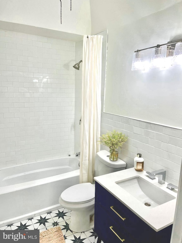 bathroom featuring vanity, toilet, tile walls, and shower / tub combo