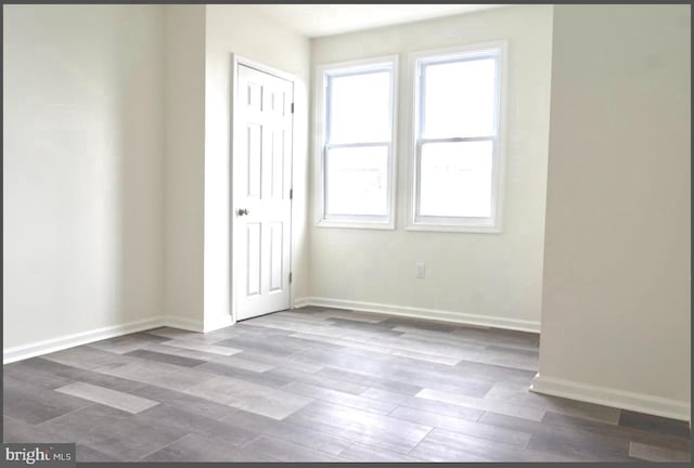 unfurnished bedroom featuring a closet, baseboards, and dark wood-style flooring